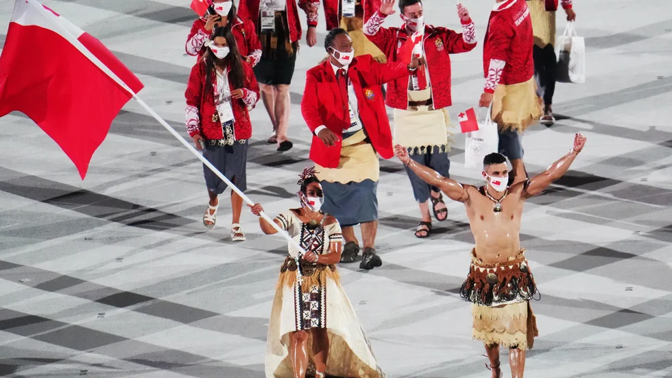 Pita Taufatofua, höger, och Malia Paseka, vänster, när Tonga tågade in på Olympiastadion i Tokyo.