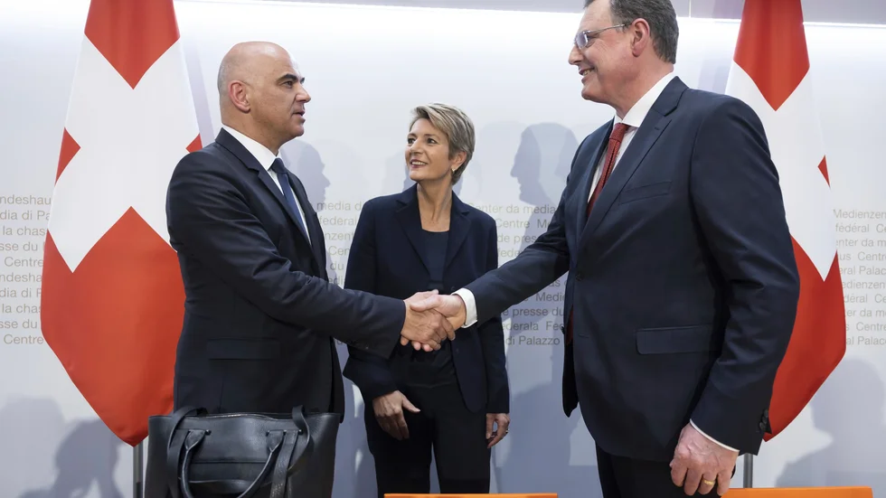 Krisbanken tvingades att upphöra, och bli slukad av sin största konkurrent.  Politiken i Schweiz ingrep hårdhänt när landet annars kunnat orsakat internationell finanskris. De som höll i yxorna: Alain Berset (tv), socialdemokratisk inrikesminister (i år regeringsordförande i Bern), Karin Keller-Sutter, liberal finansminister  samt Thomas Jordan, riksbankschef.