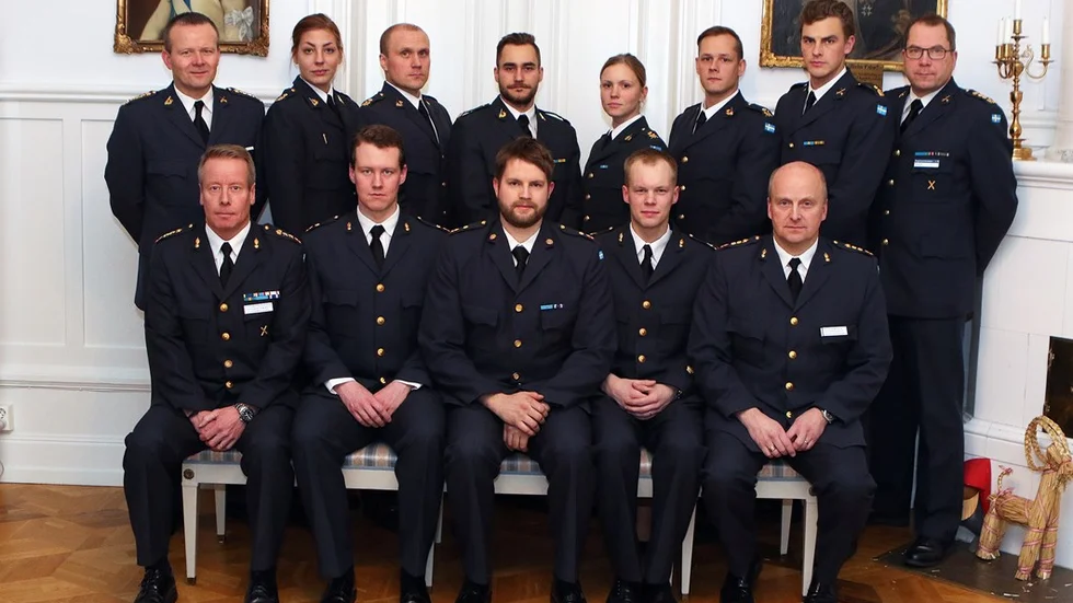 Nya specialistofficerare vid I 19. Stående från vänster:  Sarah Öster, Thomas Yliniemi, Hubert Danielsson, Catrin Warrebäck, Dennis Eliasson och Marcus Snäckerström, flankerade av regementschefen, överste Mikael Frisell och regementsförvaltare Jari Mäkelä. Sittande från vänster, nya specialistofficerare vid A 9 : Dick Alvarsson, Mats Lundström och Pontus Frank, flankerade av ställföreträdande regementschefen, överstelöjtnant Stefan Fredriksson och regementsförvaltare Peter Hemphälä. Saknas på bild: Mikael Sandling och Moa Raattamaa som kommer att tjänstgöra vid pansarbataljonen.