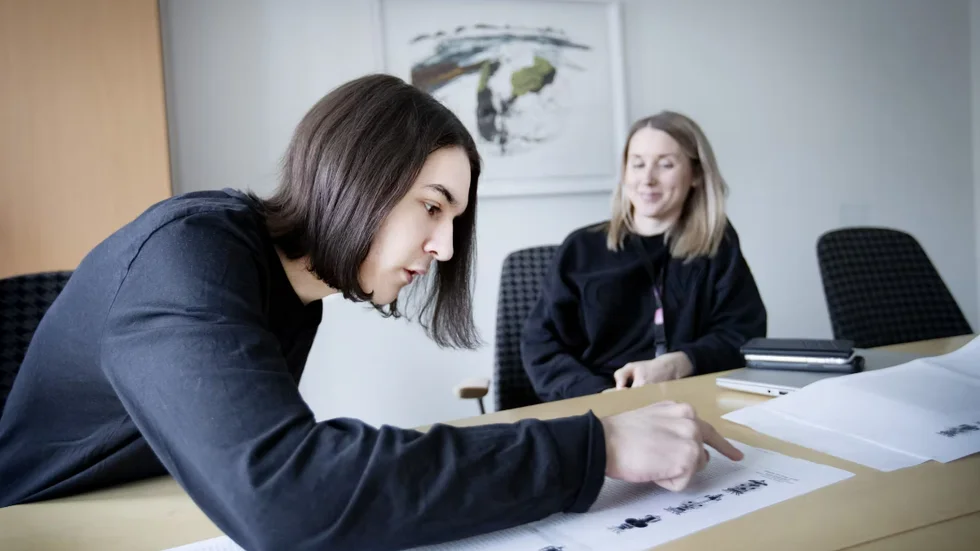 Klaus Andrei och Linda Ingman som jobbar på skolan kikar på utskrifterna av alla decimaler. De fungerade som facit när Klaus drog alla siffror muntligt.