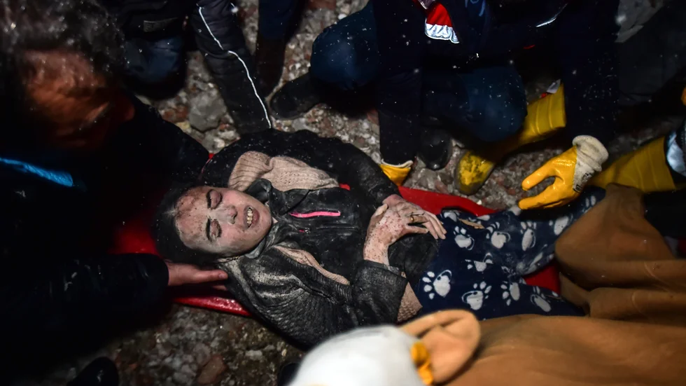 En kvinna bärs ut ur rasmassor i Elbistan, Kahramanmaras.