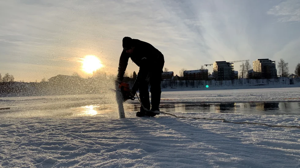 Jocke Lundqvist sågar upp isen inför vintersimmet.
