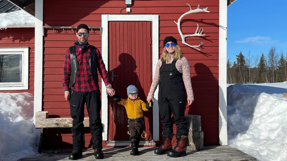 Daniel tillsammans med sonen Harry och frun Johanna framför deras stuga i Akkavaara. 