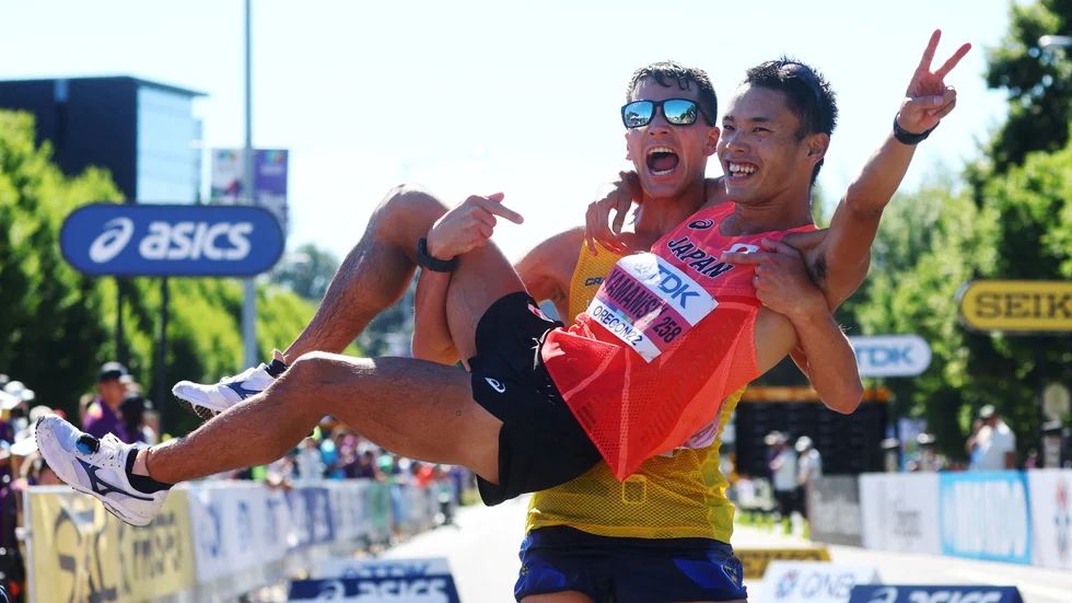 Perseus hissar guldmedaljören Toshikazu Yamanishi från Japan efter loppet i Eugene.