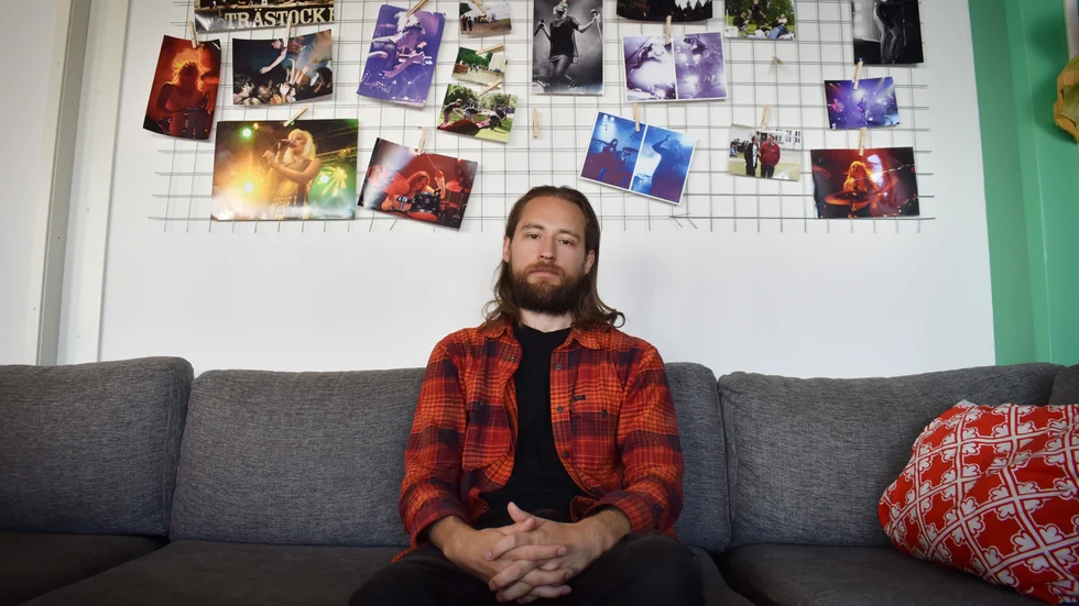 Jonathan Norén Brännström har varit engagerad i Trästockfestivalen sedan han var 17 år. På väggen bakom honom hänger bilder från tidigare års Trästockfestival. 
