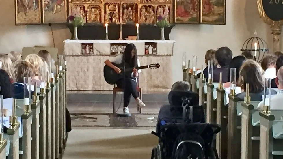 Niondeklassaren Julia framförde stämningsfullt låten Cherry Wine av Hozier inför klasskramrater och vuxna åhörare .
