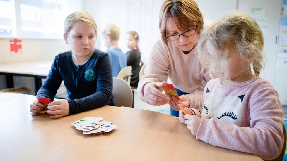 Innehållet är planerat för tio lektioner och svårighetsgraden kan anpassas för olika åldrar. På Tigerns fritidshem på Sandbäcksskolan går elever från förskoleklass till årskurs två. Maja Aderteg och Irma Siverskog får hjälp av Maria Wallin med kortspelet Blink.