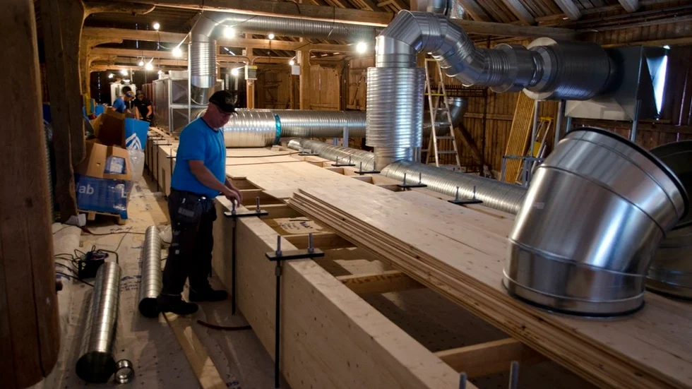 En omfattande ventilationsanläggning fyller det gamla höloftet. Därifrån bär också en "värstingkonstruktion", med limträbalkar i metallhängslen, upp festsalens tak.