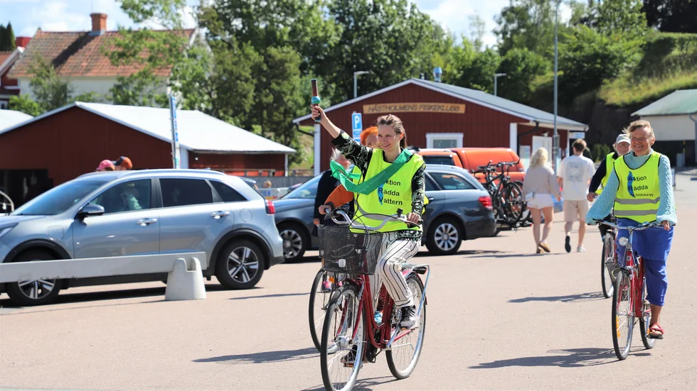 Rebecka Le Moine (MP) på väg in i Hästholmens hamn för att lämna över budkavlen runt Vättern tillsammans med Aktion Rädda Vättern.