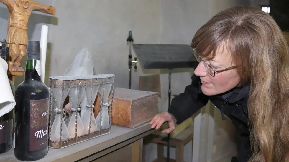 Konservator Eva Svenning studerar de gamla föremålen i Hogräns kyrka som är täckta med brandsläckningspulver.