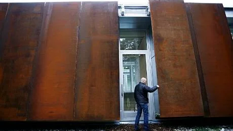 Ingången göms bakom en av cortenplåtarna i fasaden. Det är plåtar som inte rostar men med tiden får en rödbrun patina.