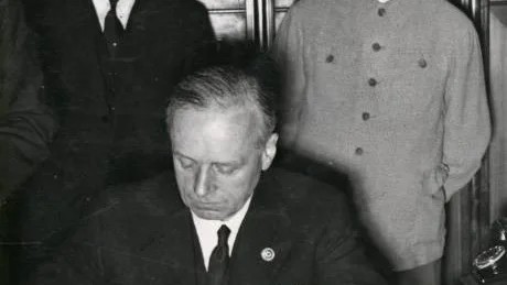 Hitlers utrikesminister Ribbentrop skriver under pakten med Sovjetunionen. Molotov och Stalin är nöjda.