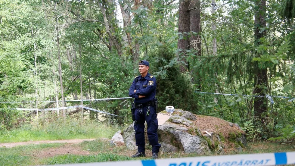 En polis på vakt på mordplatsen i Årbyskogen, dagen efter mordet.