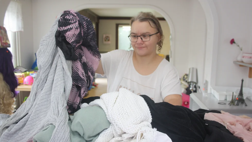 Linnea Johansson sorterar bland nyinkomna textilier.