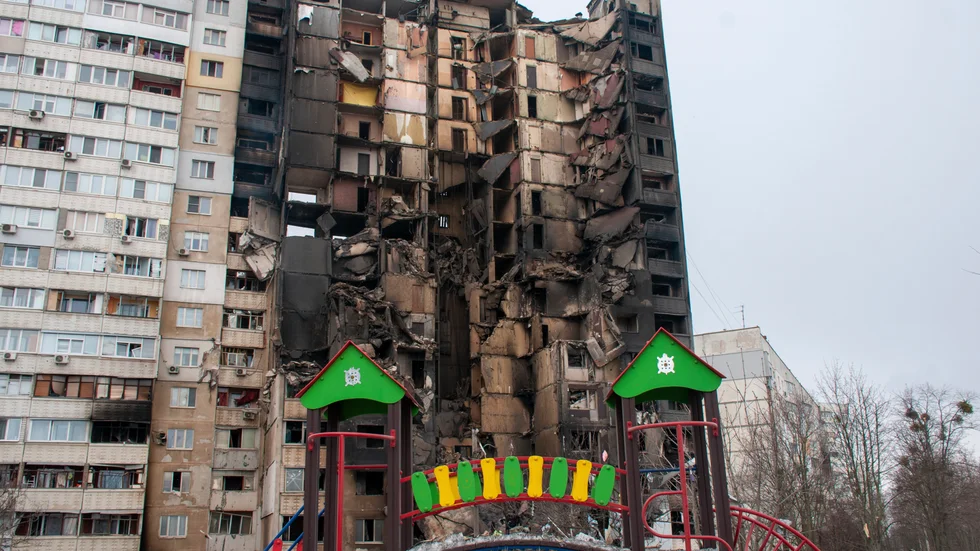 Lekplats framför flerfamiljshus som skadats av granateld i Charkiv i Ukraina. Arkivbild.
