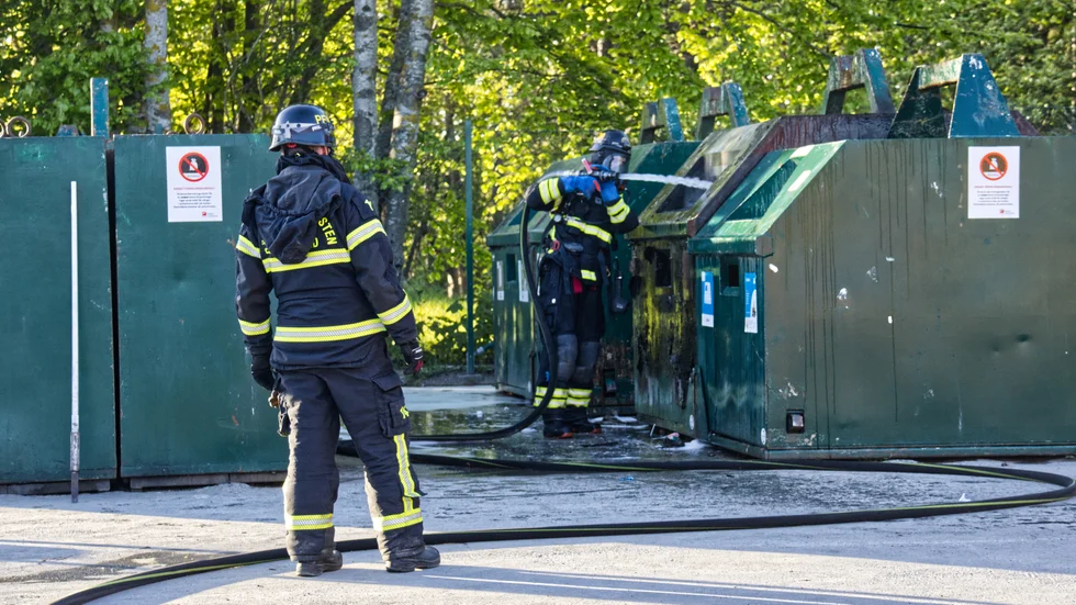 Räddningstjänsten släcker branden i containern. 