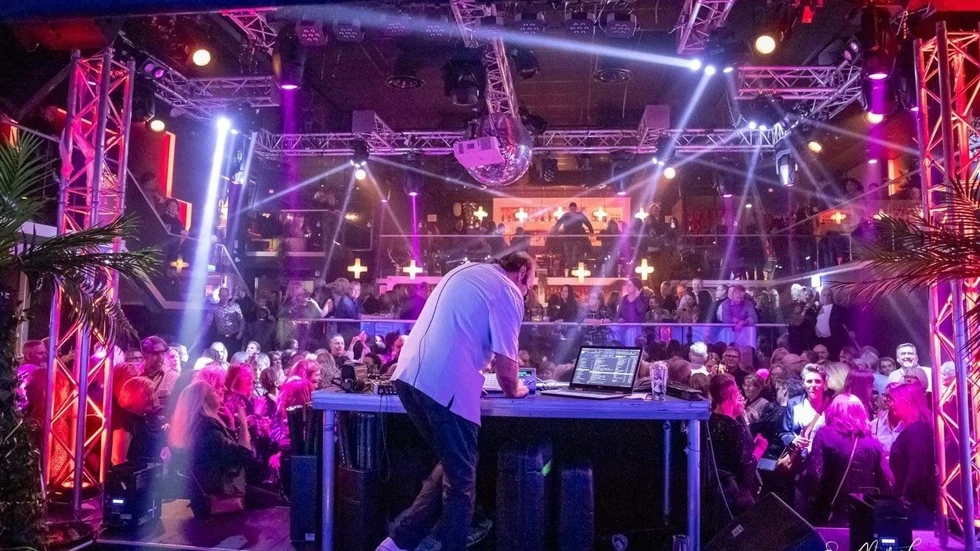 Johnnie Karlsson på scen framför en livlig publik på Love 50+ Party. 