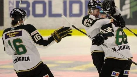 Fredrik Lindgren (nummer 16) och Per Åslund uppvaktar Mikael Johansson som prickat in 2-1 till Färjestad.