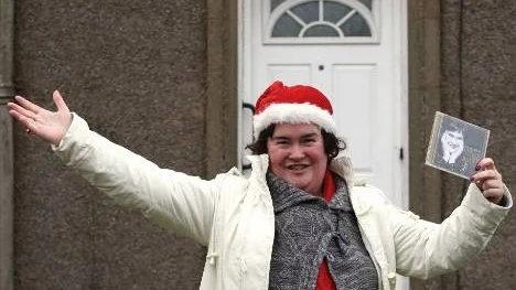 British Singer Susan Boyle gestures as she holds her new album outside her home in Blackburn, Scotland, Tuesday Dec. 1, 2009. (AP Photo/PA, Andrew Milligan) ** UNITED KINGDOM OUT  NO SALES  NO ARCHIVE  **