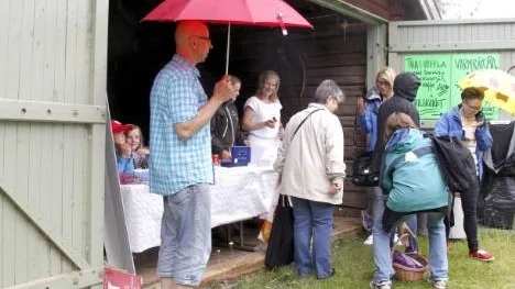 Börje Wallin hukar under paraplyet  när regnet öste ned strax innan onsdagkvällens håjladokonsert.