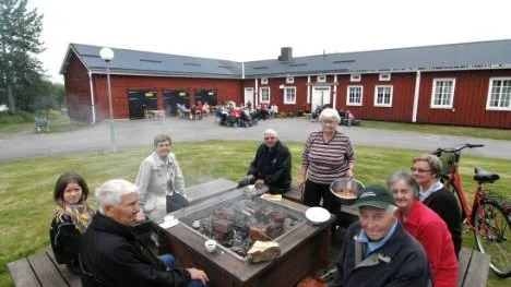 Runt Röda korsets grilleld satt gäster och grillare. Från vänster: Alf och Josefin Johansson, Ingegerd Burman, Sven Hällerstrand, Britt-Marie Westerlund, Max och Elsa Söderberg samt Christina Lenner.