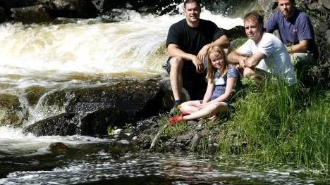 Vid laxtrappan på Fällforsens södra sida kan laxarna skådas. Några av eldsjälarna bakom byns fina laxcentra är: Tomas Johansson, fiskeriassistent och Tony Söderlund, fiskerikonsulent i Skellefteå kommun. Framför dem syns Hans Lundqvist från byaföreningen och hans dotter Lovisa.
