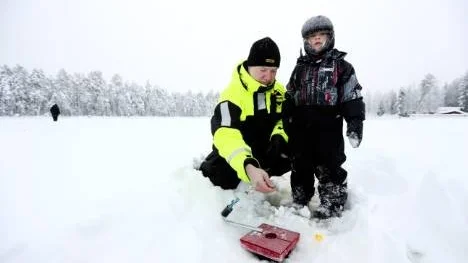 Elin Nilsson, 4 år, trotsade kylan för att kolla när morbror Krister fiskade på Holsträsket i Norrfjärden.
