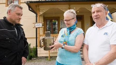 Inger Boman, ordförande i Arvidsjaurs hembygdsförening, fick på fredagen ta emot betalbössan från Arvidsjaurs varmbadhus att införliva i hembygdsmuseets samlingar. "Den hör hemma i Arvidsjaur, säger Nils-Peter Sundberg, Märsta, som haft bössan i fritidshuset i Vingåker. Till höger bygdeforskaren Lennart Öhman.