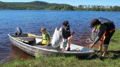 Enklaste sättet för Axel Jonsson (till höger) och kompisarna Gunnar Nordlund och Hugo Bergman Bäcklin att komma till badplatsen är att åka båt. "Skeppare Jonsson" förtöjer den med van hand.