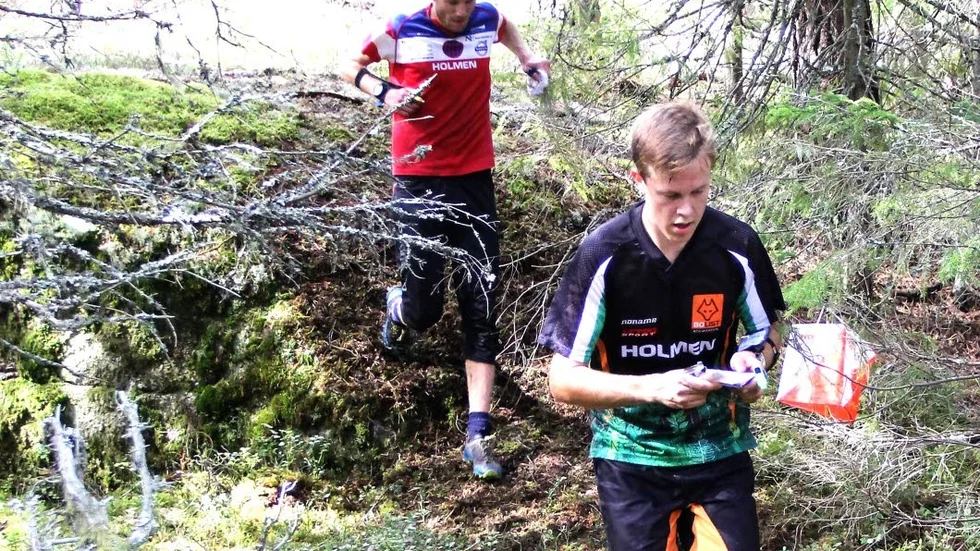 Först. Oskar Leinonen, OK Kolmården har tagit kontrollen och läser in mot nästa medan Petter Eriksson, Ärla är på väg in att stämpla vid skärmen.