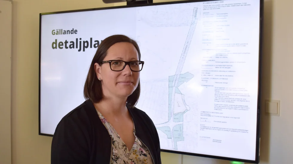 Anna Lundström är kommunens projektledare. I bakgrunden syns den gällande detaljplanen, som visar var bron kan byggas. 