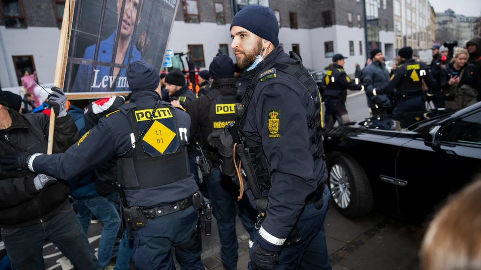 Poliser föser undan demonstranter utanför rättslokalen i Köpenhamn där statsminister Mette Frederiksen (S) förhördes av en kommission om beslutet att massavliva landets minkar.