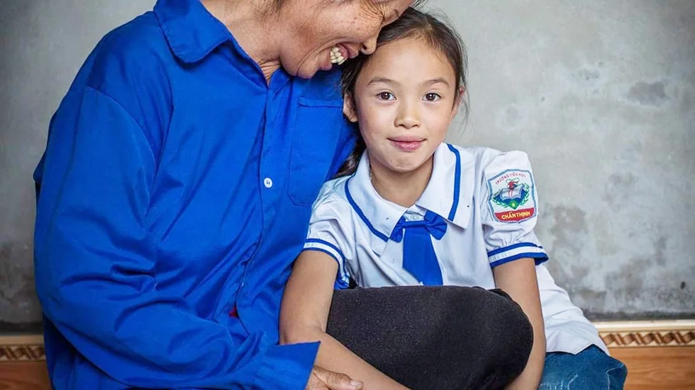 Nguyen Thi Su och barnbarnet Mai Tuyet fick med stöd från We Effect hjälp att bygga ett starkare hus som ersättning för det som förstördes i en storm. Foto: Marcus Lundstedt/We Effect