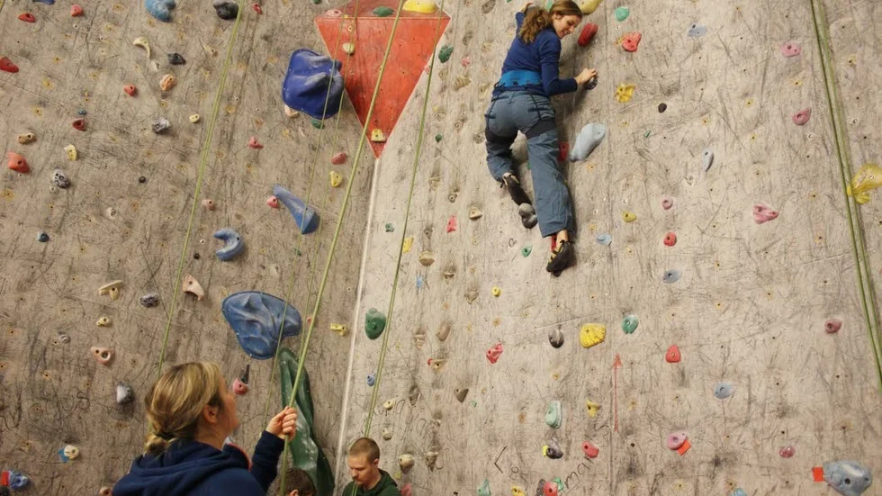 Sara Ljungdahl är på väg uppåt på den 15 meter höga klätterväggen. Till vänster Malin Söderberg, som håller i säkerhetslina.