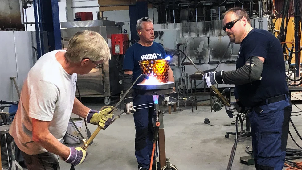 Glasblåsarna putsar glaset blankt med svetslåga efter att det formats. Från vänster Stefan Nyrén, Ronnie Ståhl och Ulf Engstrand. 