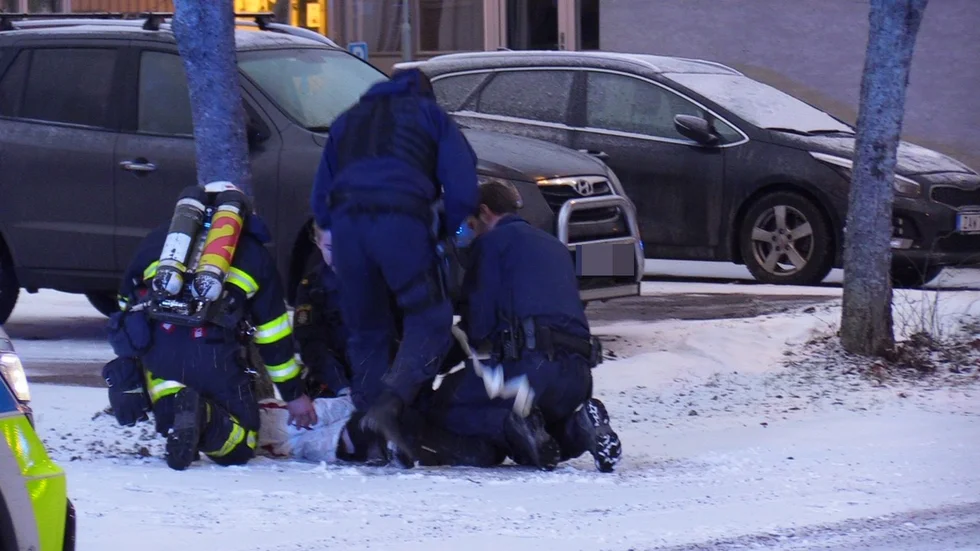 Brandmän och polis hjälps åt med ett gripande.