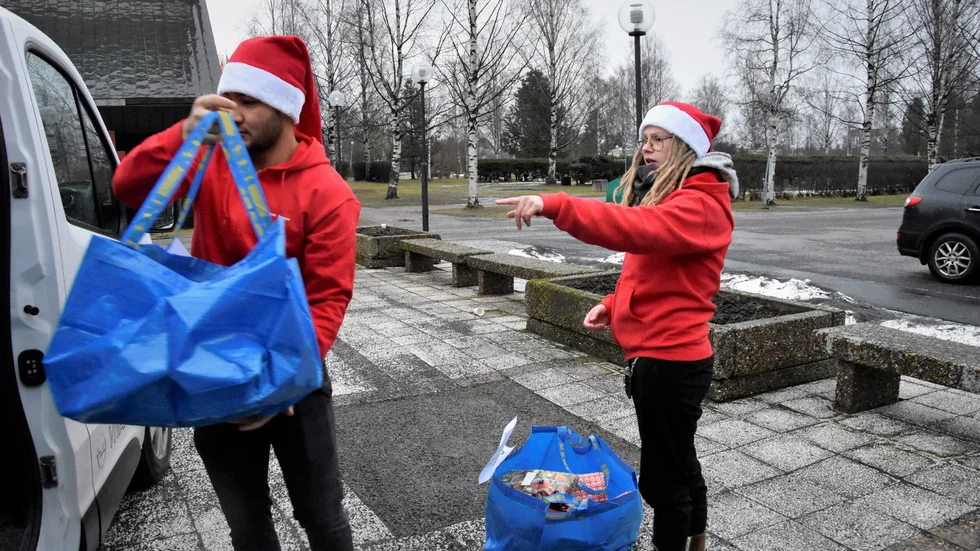 Ehsan Nazari och Hanna Tolvanen lastar in kassarna med paket i minibussen.
