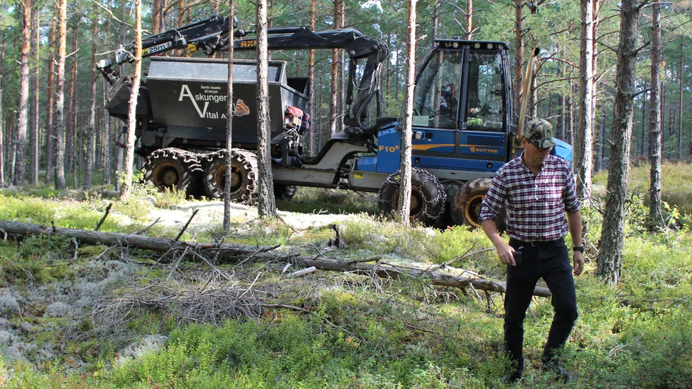 En skotare med flak och spridare där bak skjuter ut klumpar av aska i skogen. Jan Persson på Häradsmarken AB måste dra sig undan lite. 