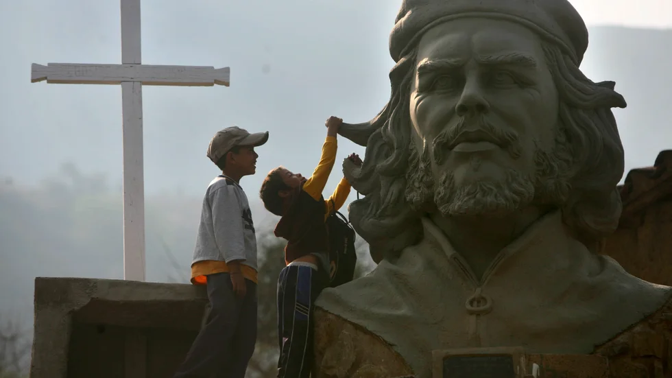 Barn leker vid en skulptur föreställande den argentinskfödde revolutionären Ernesto "Che" Guevara i byn La Higuera i Bolivia där han dödades för 53 år sedan. Arkivbild.