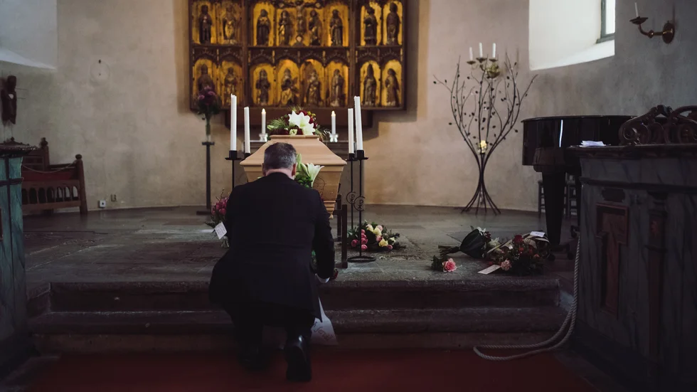 Ungefär en timme innan gästerna anländer är Mattias Schmidt på plats i kyrkan. Här ställer han i ordning buketter runt kistan och dubbelkollar att alla blommor kommit till rätt begravning.