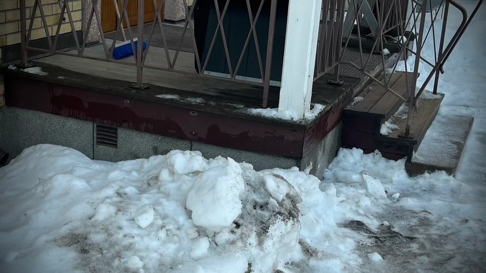 Sotig snö nedanför farstukvisten till den fastighet i centrala Luleå som kan ha utsatts för en anlagd brand i söndags. 