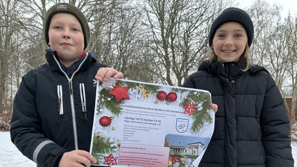 Elever på Hummelstaskolan, Edvard Bonde och Meya Johansson, visar en flyer med den nya julmarknaden de fått ordna själva.