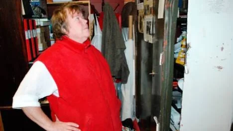 Ann Karlsson på Lill-Annas köksbod studerar det uppbrutna skåpet där pengarna förvarades.