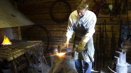 Leif Elovsson smider medan järnet är varmt. Smedjan drivs av Krokeks hembygdsförening.