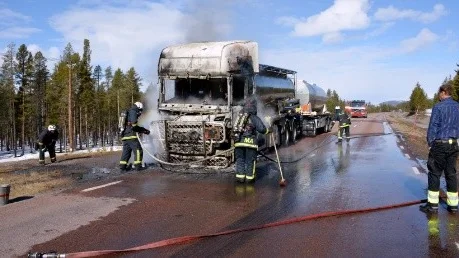 Det började med en punktering och sedan blev det en brand. Chauffören, t.h, som försökte släcka med pulversläckare tittar på förödelsen.
