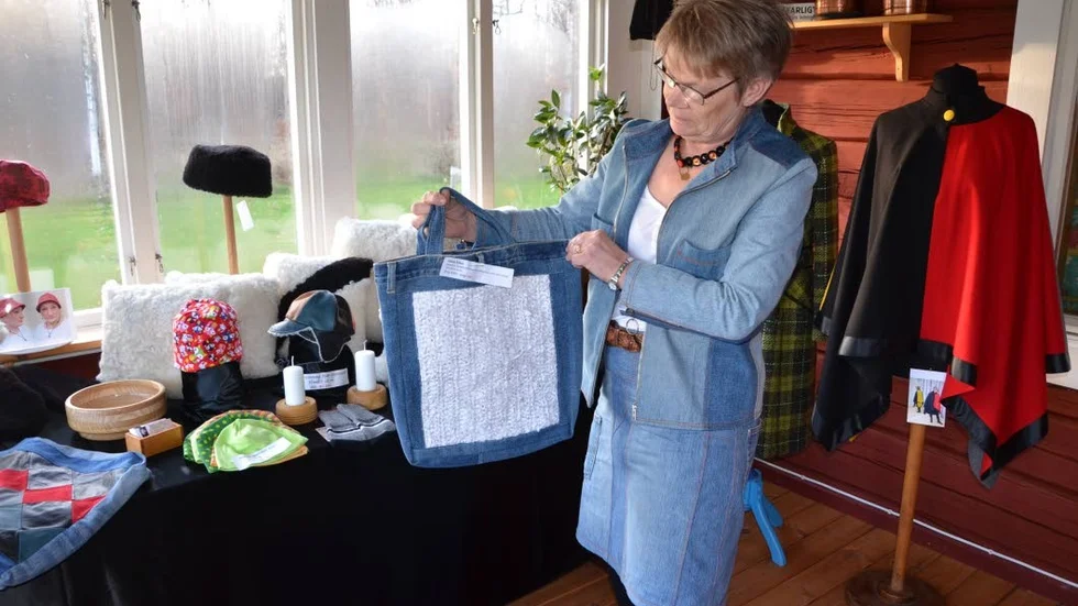 Återbruk. Det vita mönstret på väskan är remsor från en brudklänning som skulle slängas. Jeanstyget på väskan, precis som Monica Anderssons kläder är från gamla jeans.