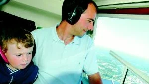 Linus Thorsell har sett fram emot att få flyga helikopter ända sedan han fick blodad tand på Lotorps marknad förra året. Pappa Stefan Thorsell passade på att kolla in sitt hus uppifrån.