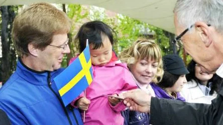 Bella Tannersjö, 2,5 år, fick en Sverigenål                   av kommunalrådet Petersen. Bellas pappa Björn tittade på.FOTO: BENGT-ÅKE PERSSON FOTO: Bengt-Åke Persson