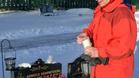 Mary Henriksson tänder ljus vid sin döde mans grav. "Arnold var så snäll och omtänksam. Det var hans tid och det är inget att göra åt, men nog är det tråkigt att bli ensam."FOTO: Marie Ridderström