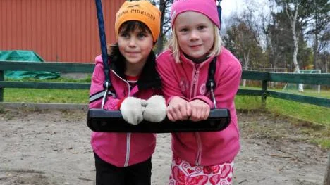 Lovisa Marjavaara och Ella Schroderus leker på skolgården utanför fritids. Ella kommer ibland till fritids redan klockan 05.30 och får ingen ordentlig mat förrän vid lunch. FOTO: Åsa Junkka